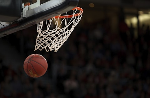 NBA篮球比赛现场精彩瞬间，球员高高跃起完成一记强力扣篮动作